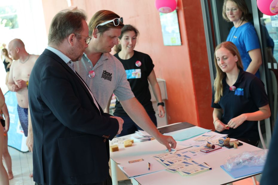 Selina Mertsch (Kasseler SV) und Uwe Hermann (DSV-Schwimmjugend) erklärten dem Minister die verschiedenen Schwimmabzeichen.    Foto: S. Sonnenschein